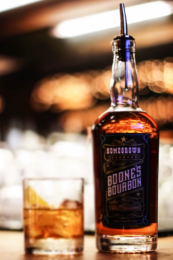 A bottle of Boone's Bourbon next to a glass.
