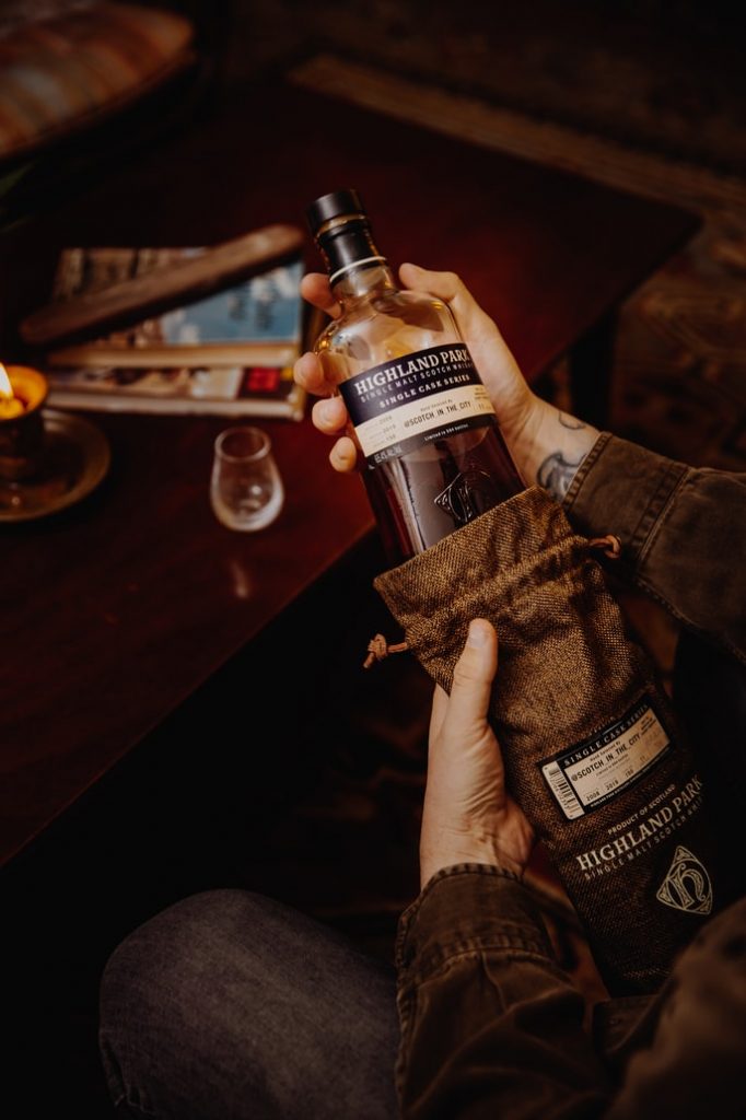 A man holding a bottle of Highland Park.