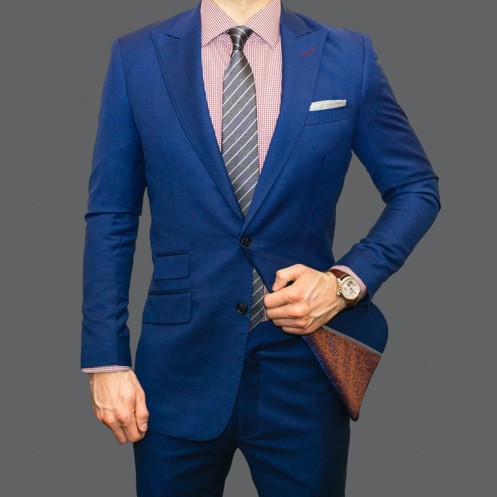 A man wearing a solid coloured suit.