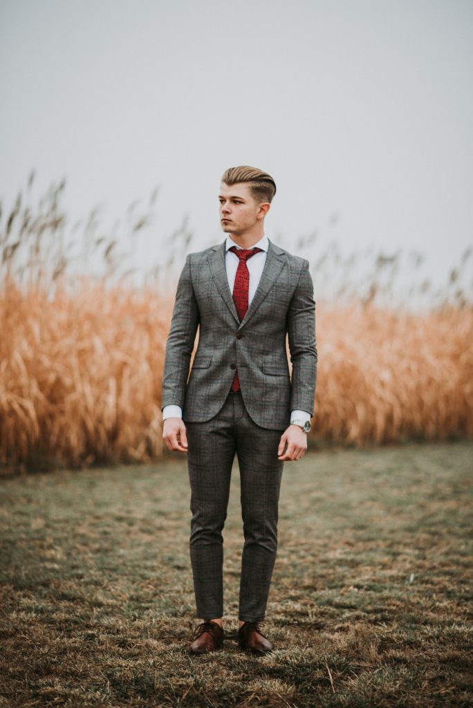 A man wearing a plaid suit in a field.