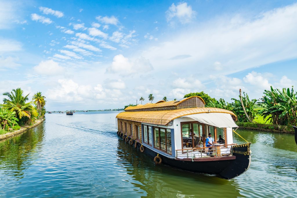 A houseboat sailing on a canal in Kerala's backwaters.