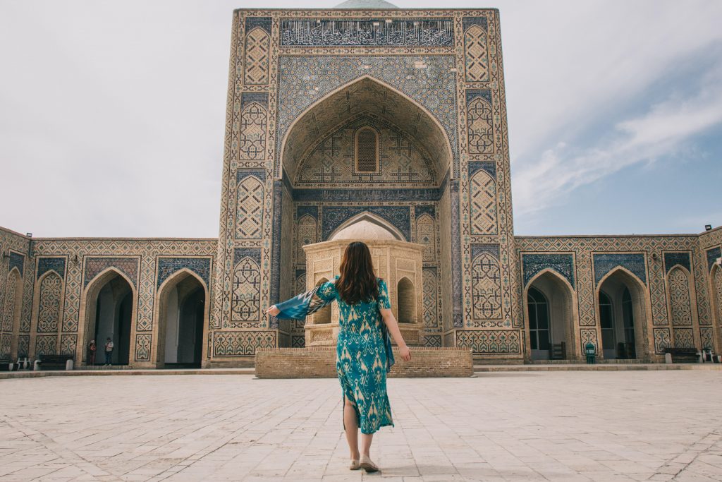 A girl standing in front of a building in Khiva, on The Silk Road.