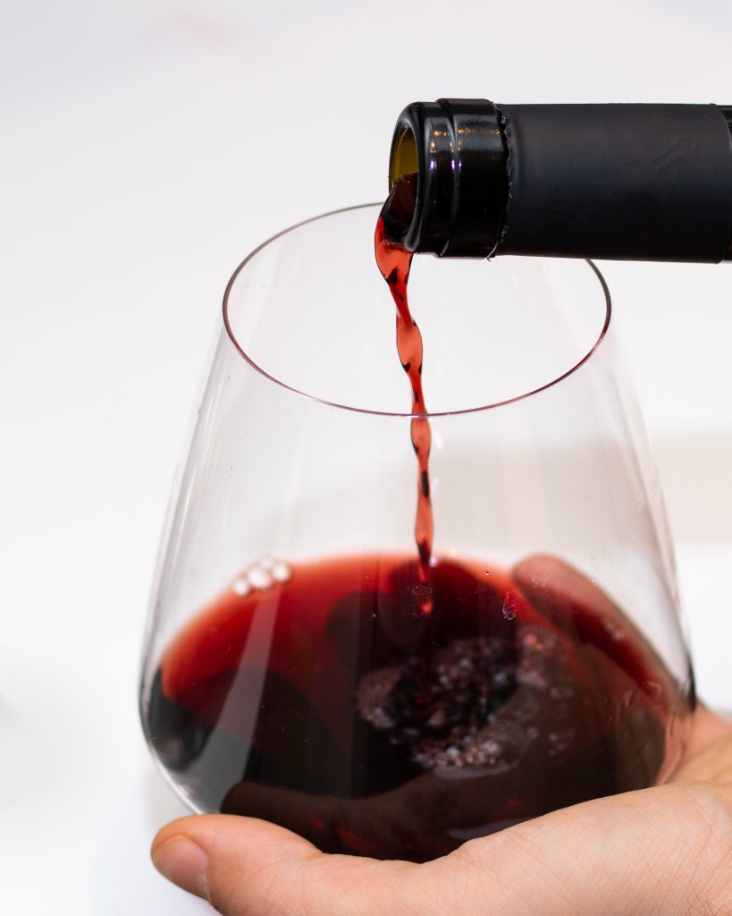 A glass with port being poured into it.
