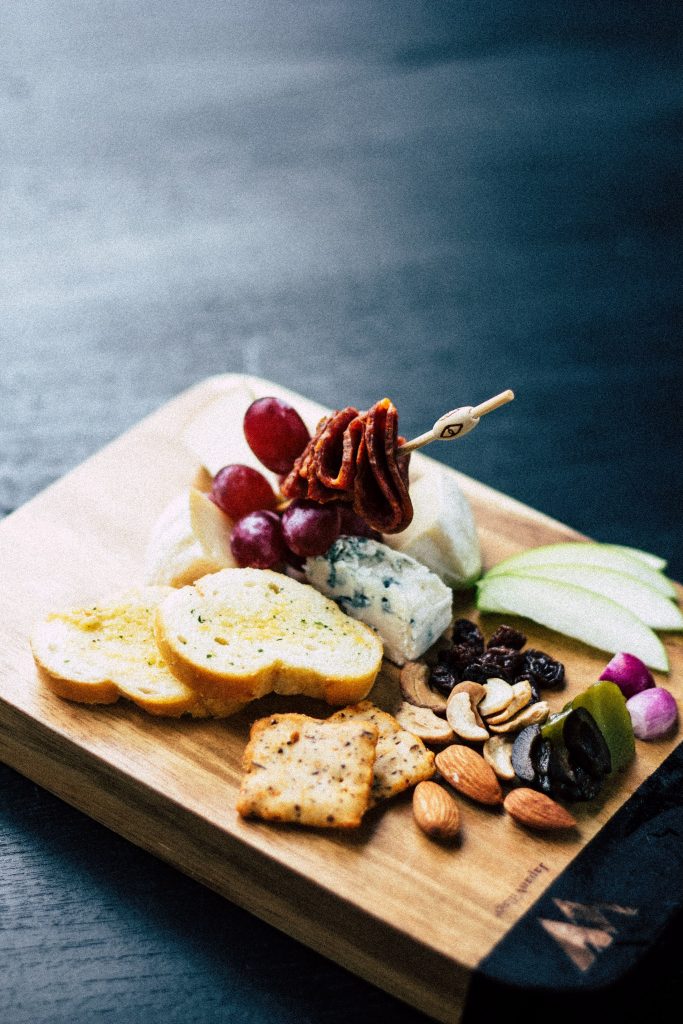 Various cheeses and nuts on a cheese platter.