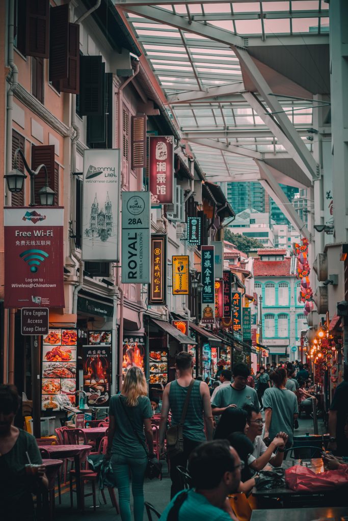 A street in Singapore with people and signs in both Chinese and English. 